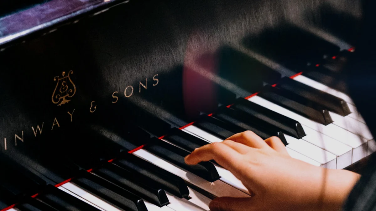Close-up of piano keys and hands playing