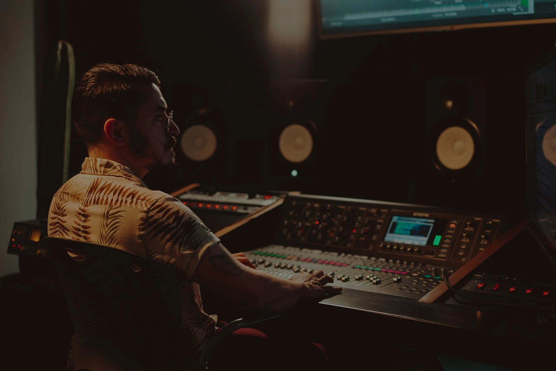 Music producer working at a studio mixing console