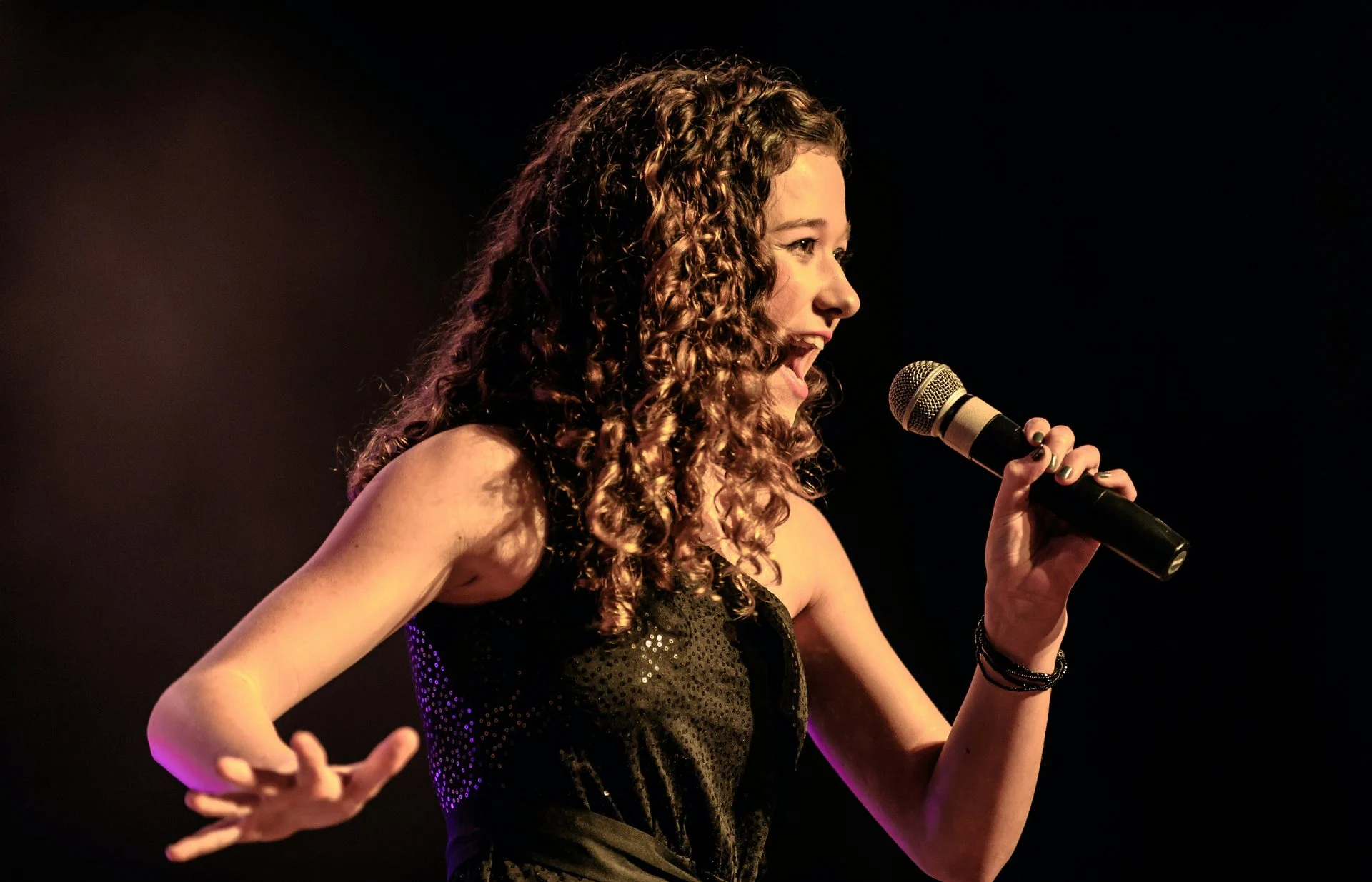 Vocalist performing on stage in a spotlight