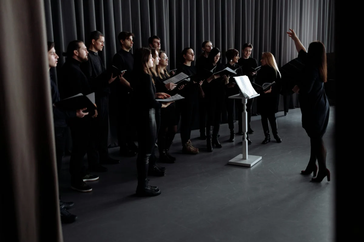Close-up of a conductor's hands with baton and score