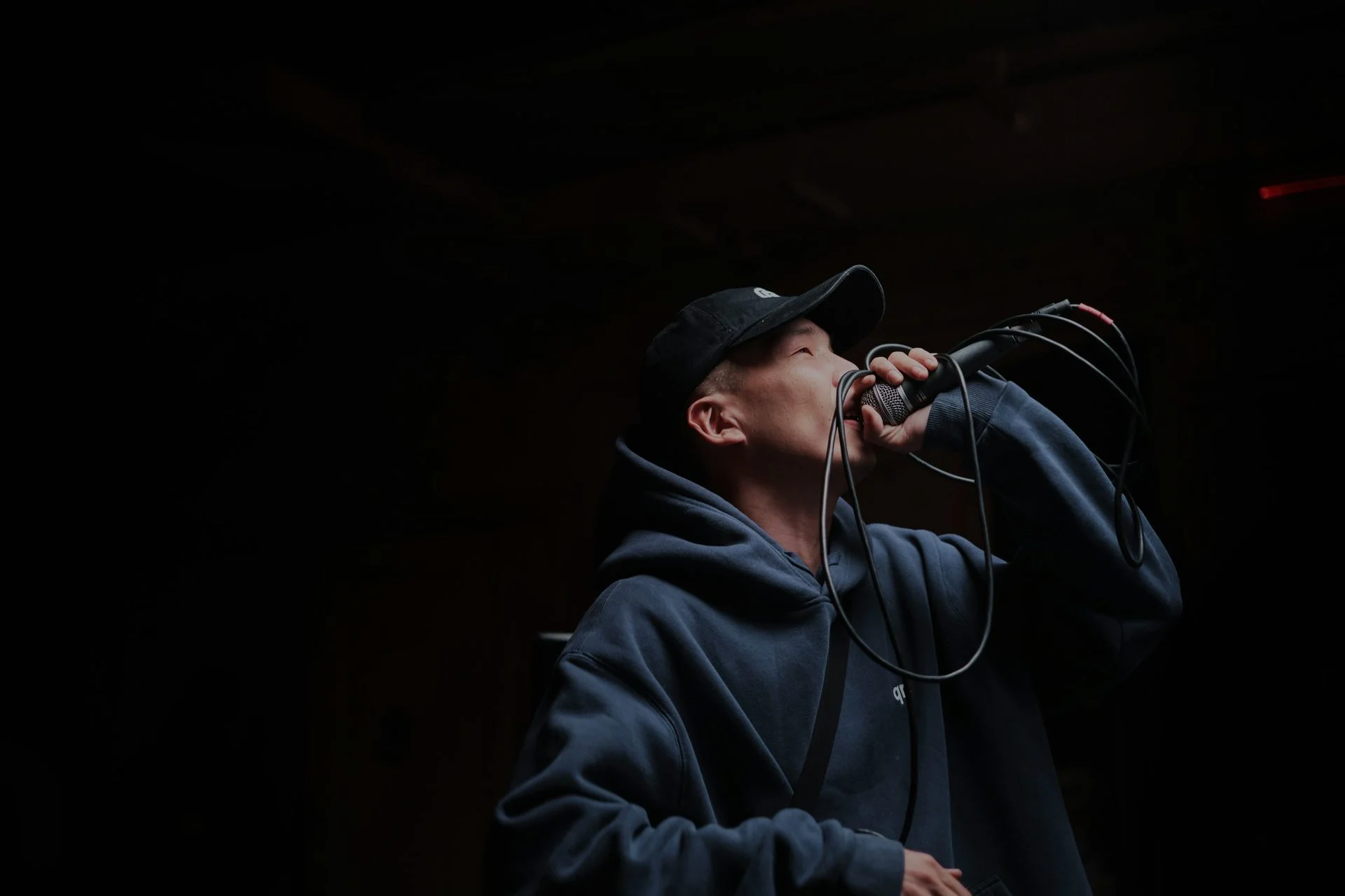 Vocalist performing with a microphone in a studio or stage setting