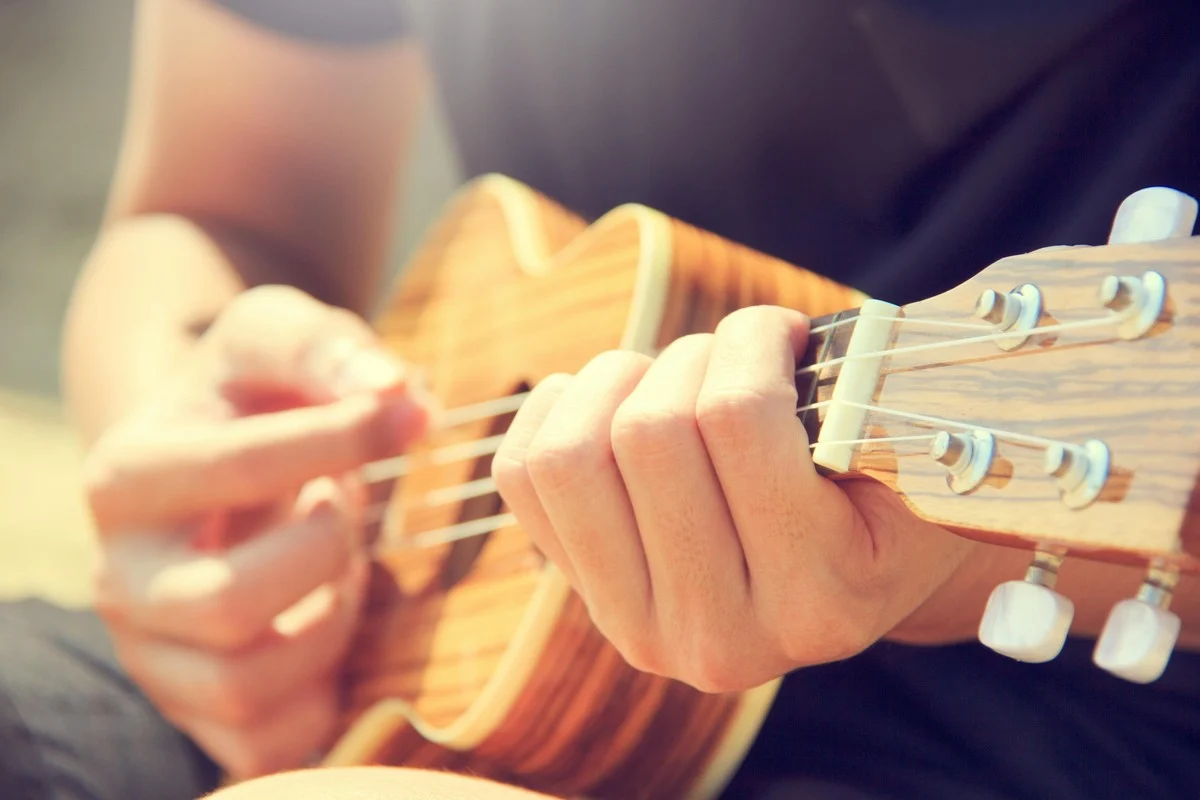 Ukulele teacher demonstrating technique for a student