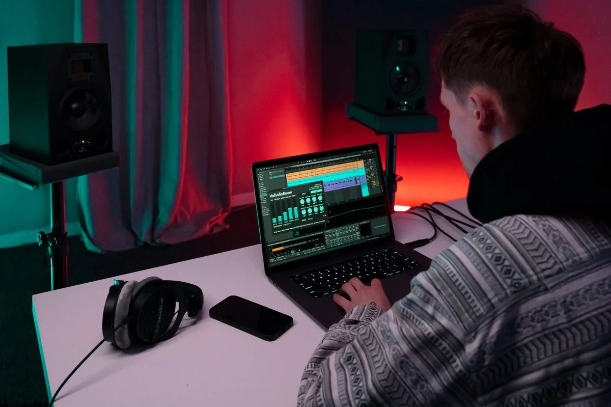 Teacher demonstrating mixing techniques on studio monitors