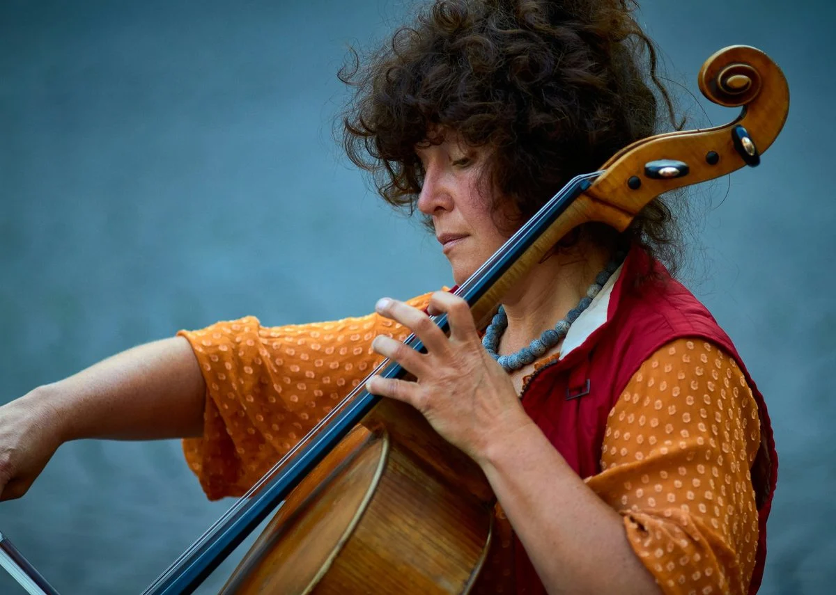 Cello teacher demonstrating technique for a student