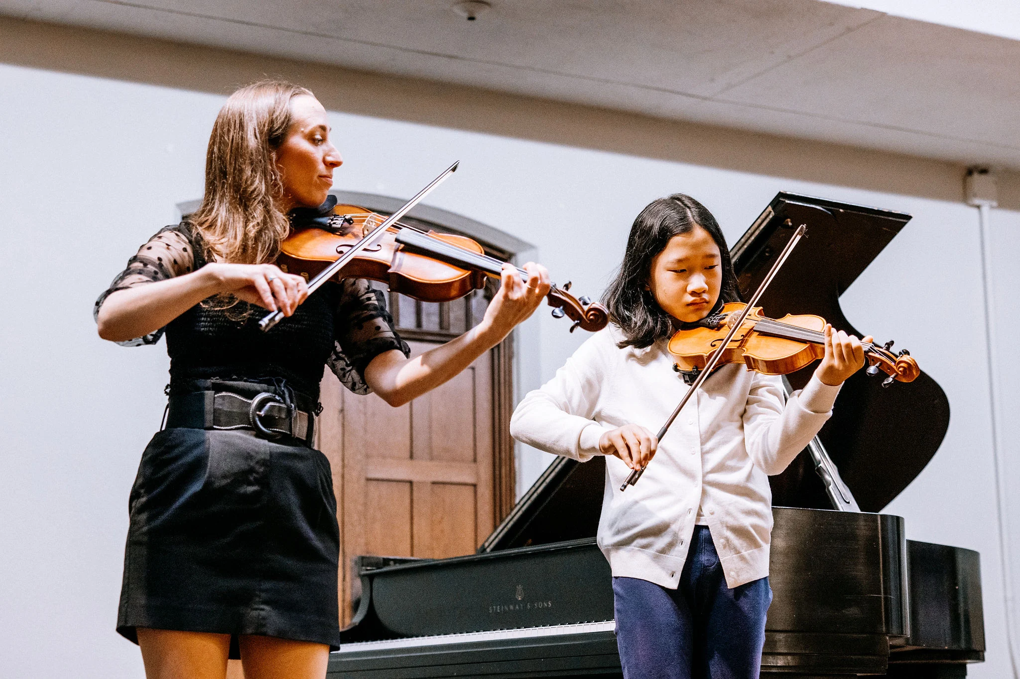 Violin teacher demonstrating technique for a student